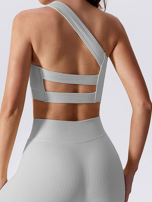 Back view of a woman wearing a sexy one-shoulder sports bra, ideal for fitness activities, made of breathable nylon and spandex.